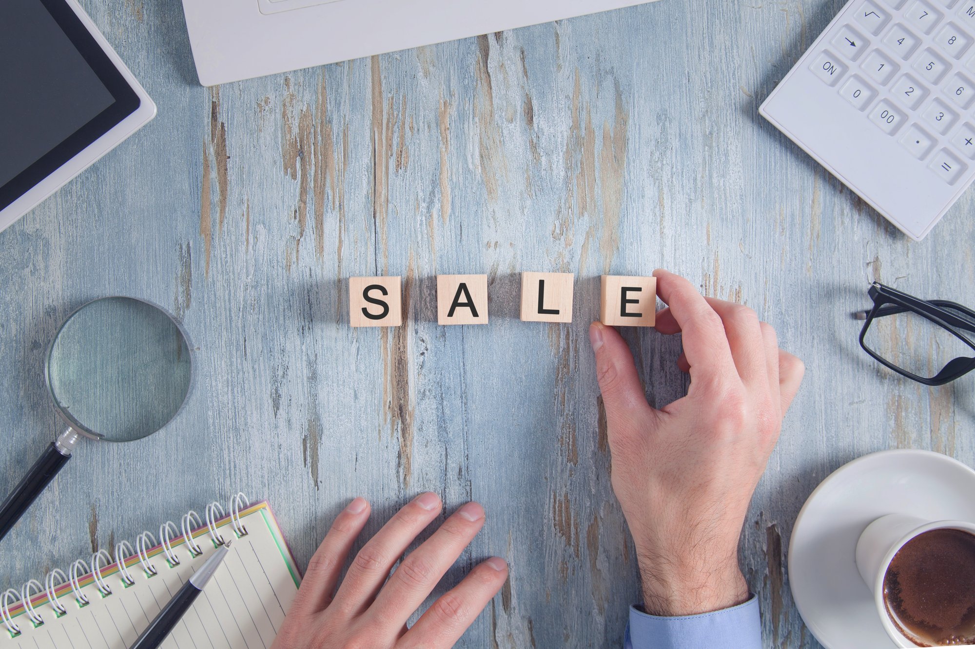 male-hand-showing-sale-word-wooden-cube